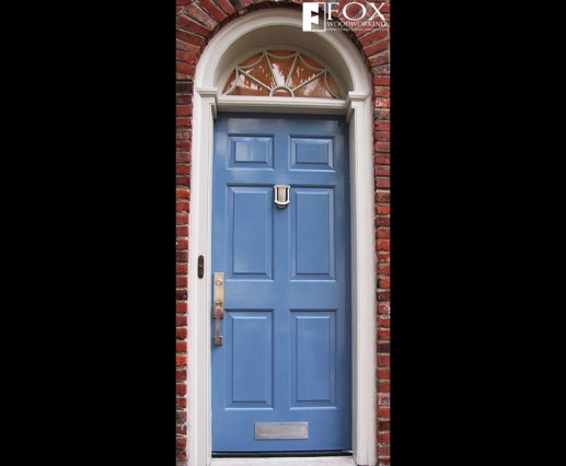 A blue painted six panel wood door.