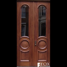 A pair of sapele doors with arched and circular moldings.