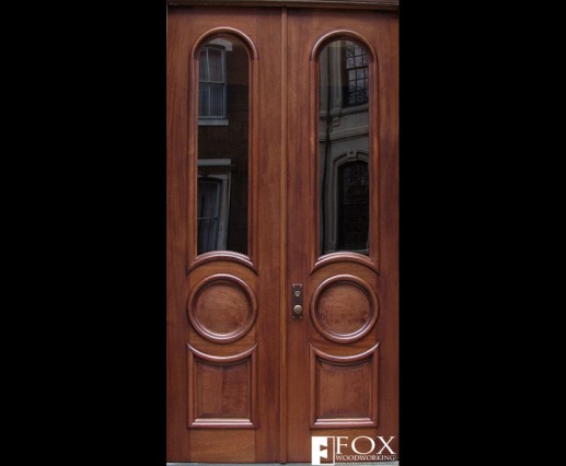 A pair of sapele doors with arched and circular moldings.