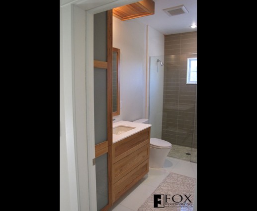 A view of the chestnut vanity, linen closet, mirror, and soffit.