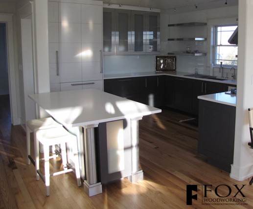 A view of the island, refrigerator, and base cabinets.