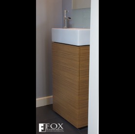 A teak vanity cabinet with a white sink.