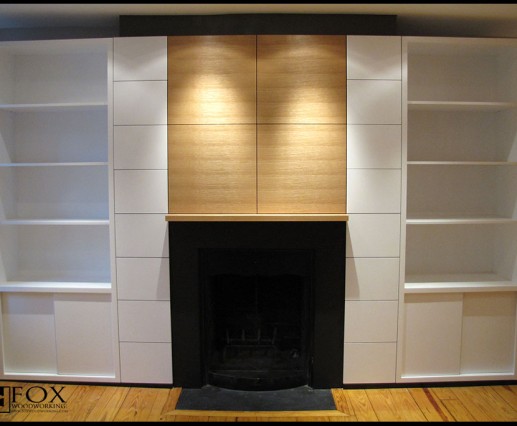 A rift sawn white oak mantlepiece and flanking white painted cabinets.