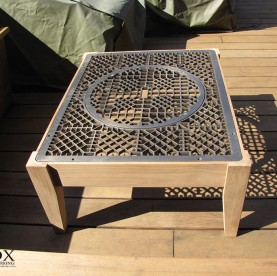 A teak deck table with a metal floor grate as a top.