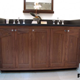 A walnut vanity with arched rail doors and matched grain stiles.